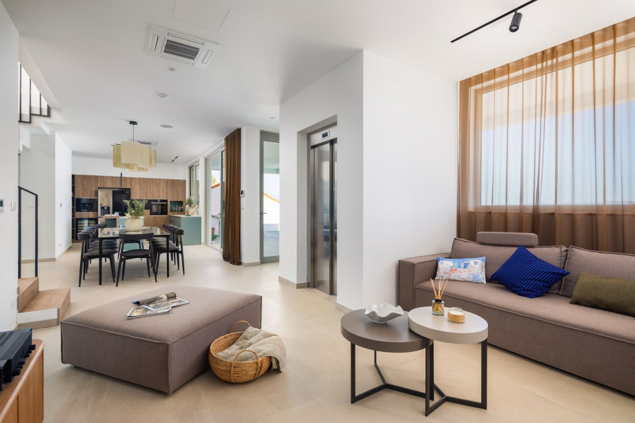 Fully furnished living area with elevator, sofa, a projector with the receiver (as a TV)