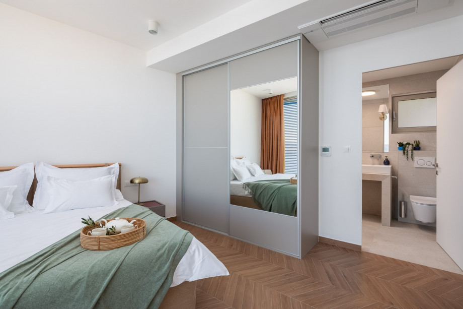 Bedroom NO1 (19 sqm) a king-size bed, a TV, an attached bathroom with a shower, and a balcony.