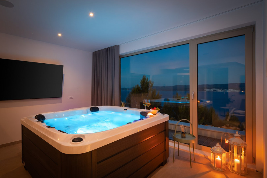 an indoor whirlpool (Hot-Tub), a Finnish sauna, a bathroom with a shower, a TV, and a kitchenette