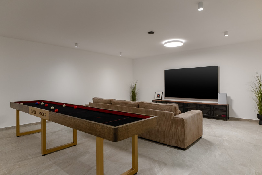 Recreational bocce table for pleasant gatherings,a flat-screen TV, and a PlayStation 5.