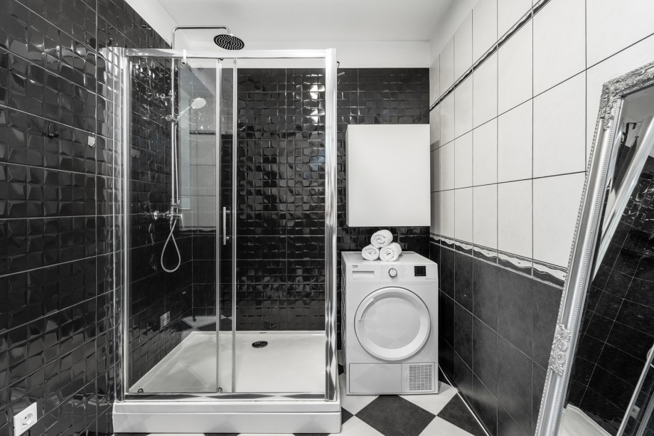 Spacious bathroom with toilet and shower, washing machine and dryer