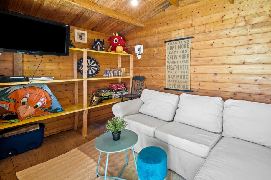A wooden play- house with toys and a play station, perfect for the youngest