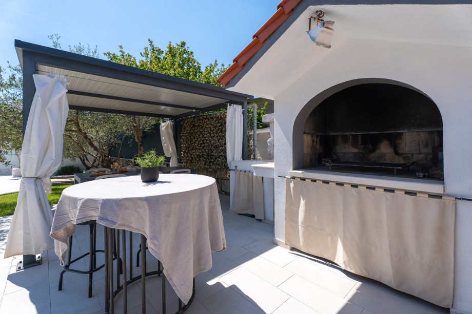 A covered dining area beckons guests to enjoy al fresco meals in style