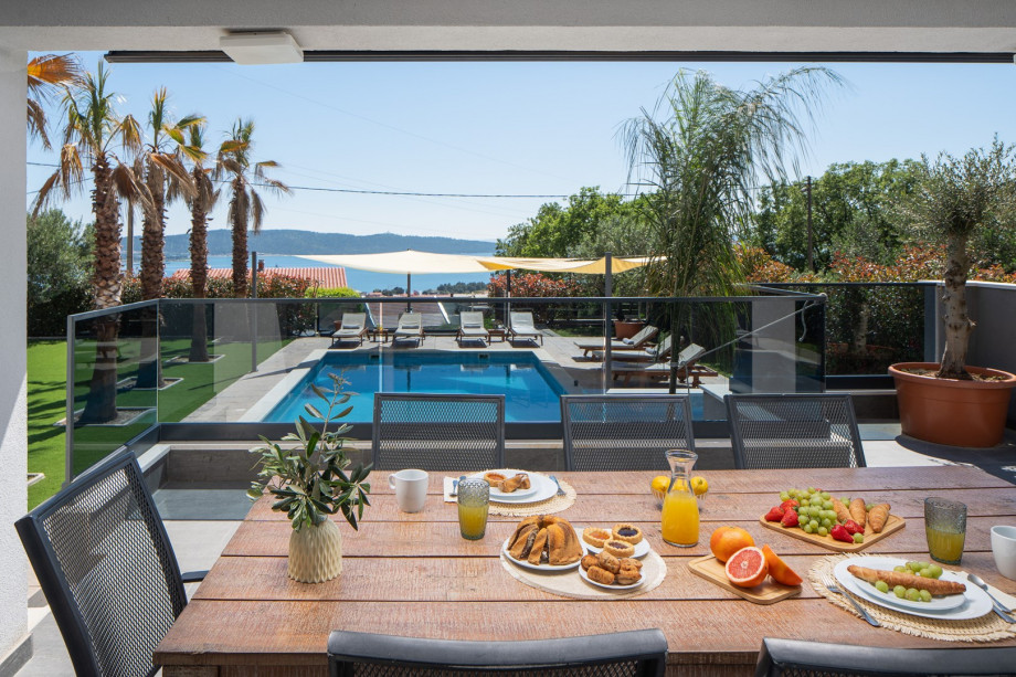 In front of the dining/living room are a covered dining area for 8 people and a very comfortable lounge corner, all with sea views.