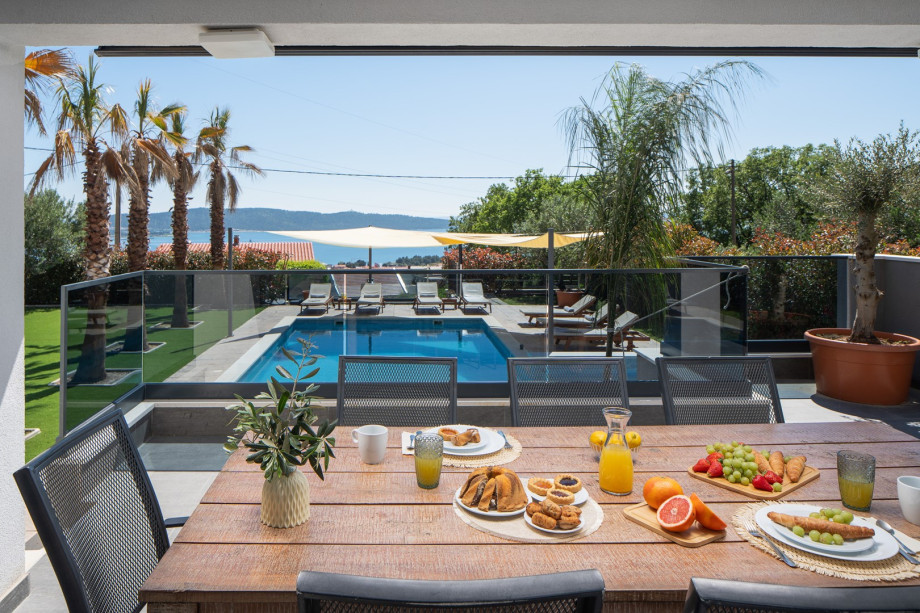 In front of the dining/living room are a covered dining area for 8 people and a very comfortable lounge corner, all with sea views.