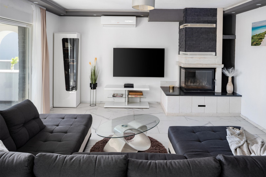 The stylish living area features a flat-screen TV, air conditioning