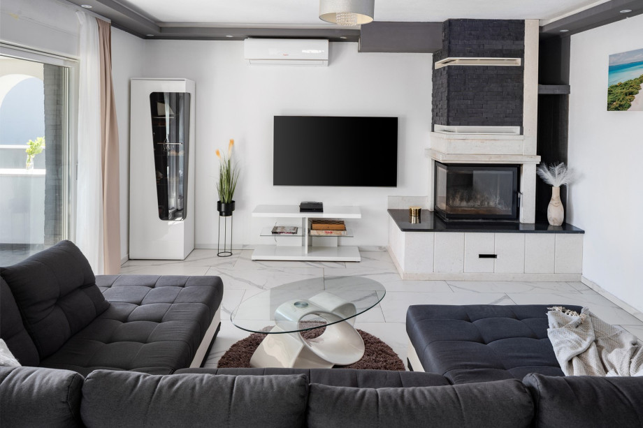 The stylish living area features a flat-screen TV, air conditioning