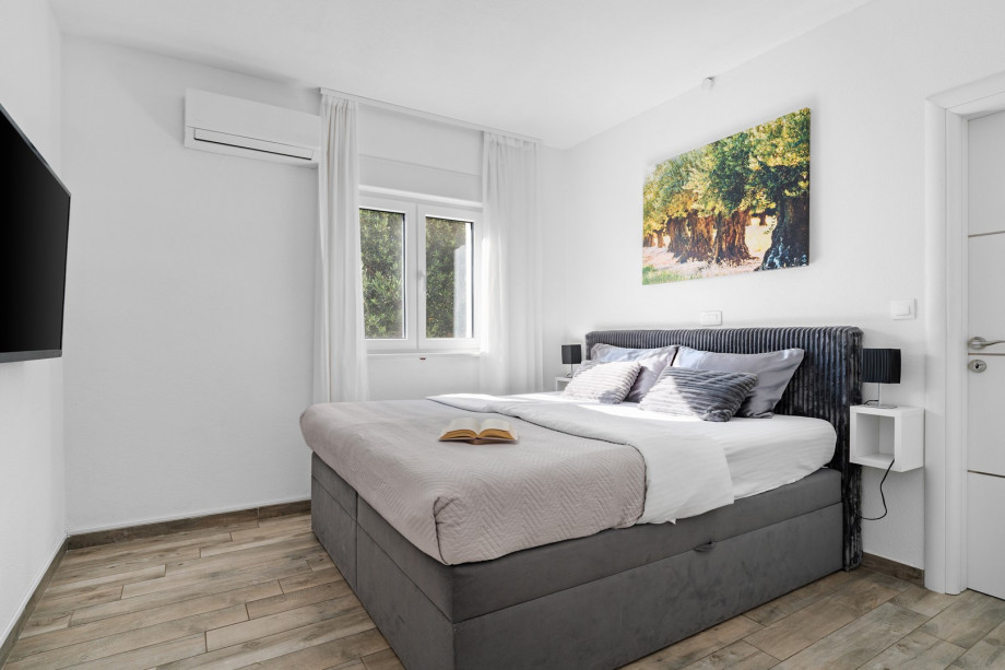 Bedroom NO1 with a king size bed (180x200cm)with air conditioning and a TV.