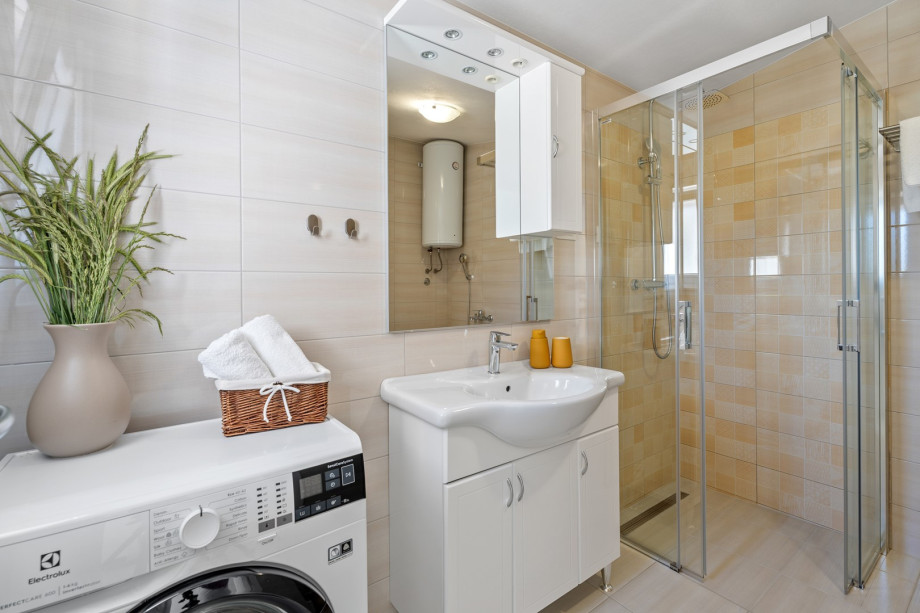 Family bathroom with
a shower, a toilet, and a washing machine.