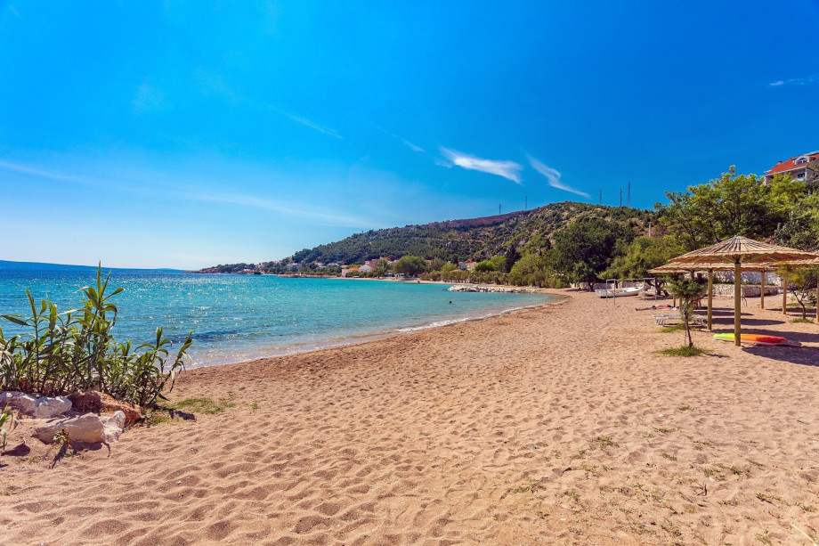 The sandy beach, nearly 1 kilometer long, features shallow, warm, and crystal-clear waters, making it ideal for kids.