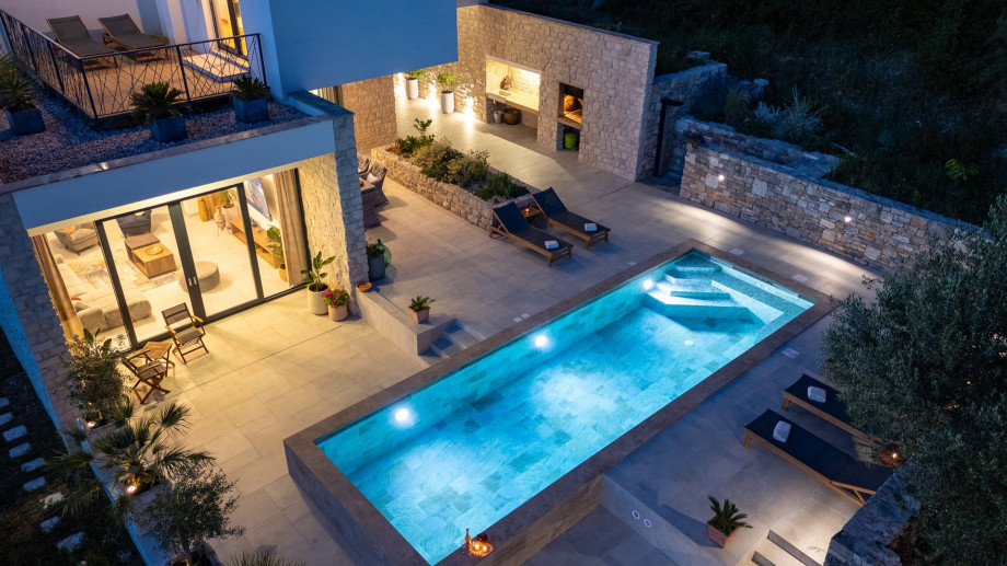 Experience the magical evening ambiance of this modern stone villa, .