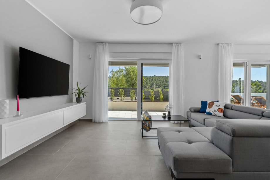 a stylish living area (42sqm) with flat screen TV, A/C, direct exit to outdoor dining area and pool