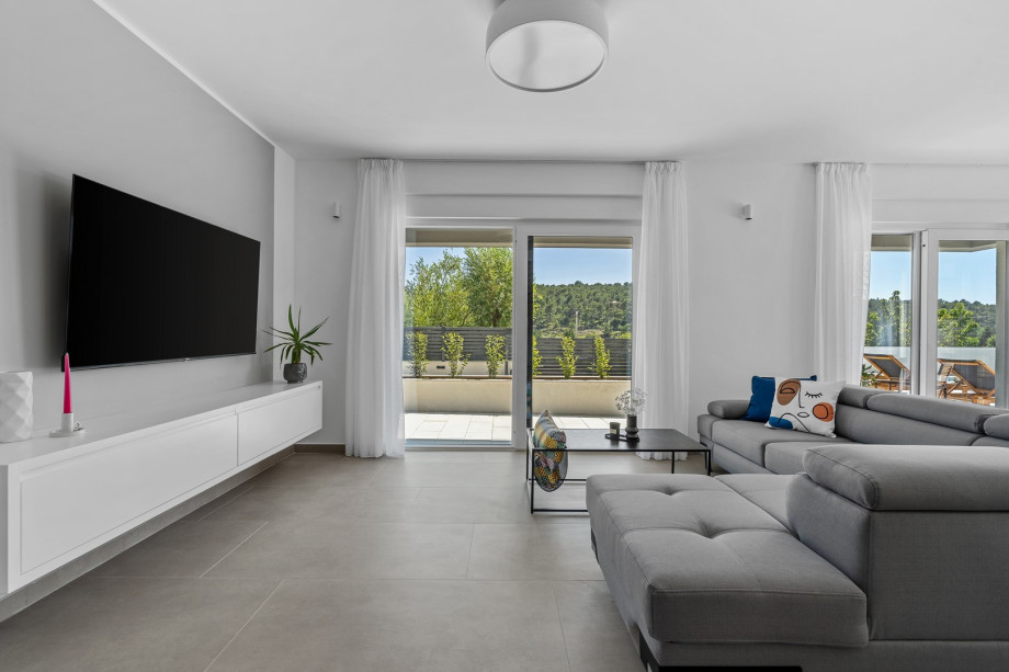 a stylish living area (42sqm) with flat screen TV, A/C, direct exit to outdoor dining area and pool