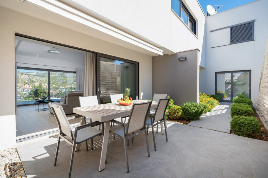 Dining area beckons guests to enjoy al fresco meals in style, complete with a summer kitchen