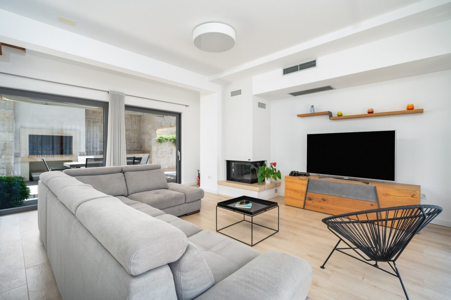 A living room featuring plush seating on a comfortable sofa, a large flat-screen TV, and a PlayStation 4 for added enjoyment