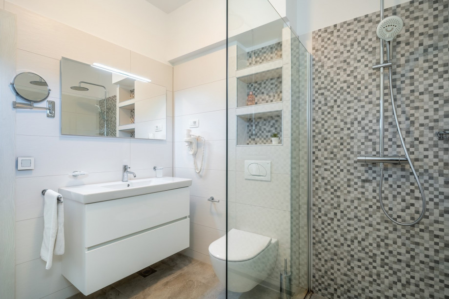 An en-suite bathroom with a shower, a sink, and a toilet