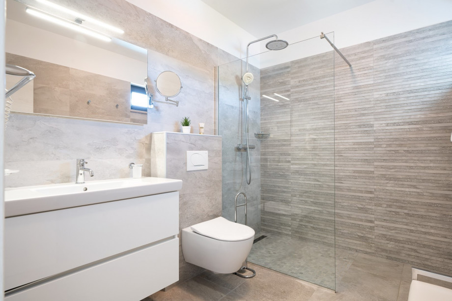 An en-suite bathroom with a shower, a sink, and a toilet