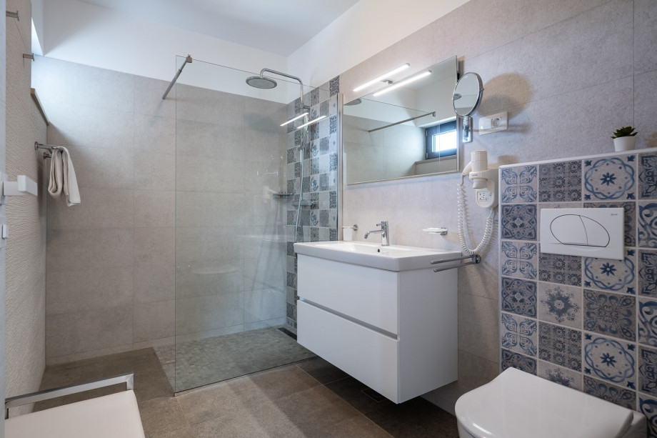 An en-suite bathroom with a shower, a sink, and a toilet