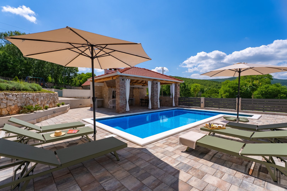 A sun deck with 6 comfortable loungers and 2 umbrellas for shade and rest