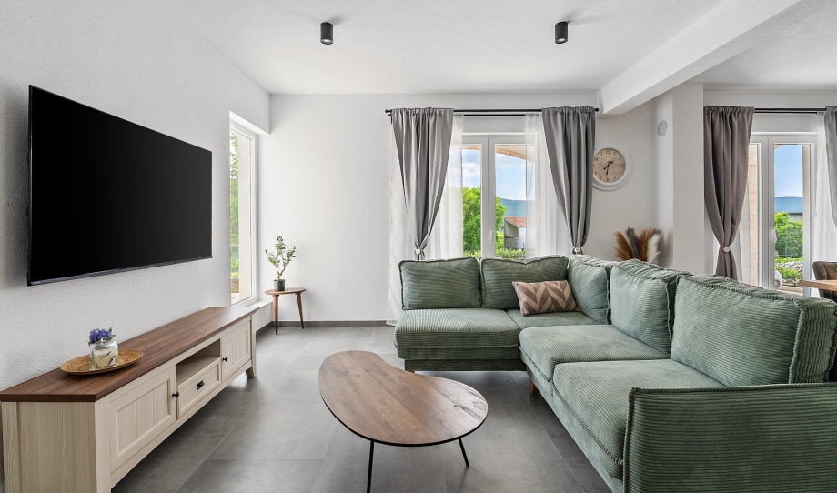 A cozy living room with a comfy sofa (can be used as a bed for 1 person), flat-screen TV, WiFi, and air-conditioning