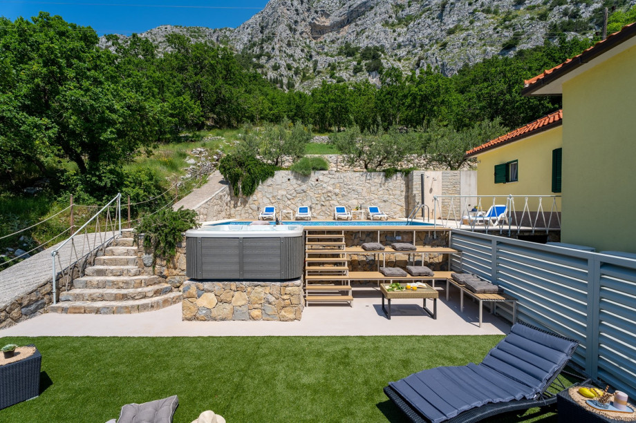 jacuzzi next to the pool, with seating and spa area