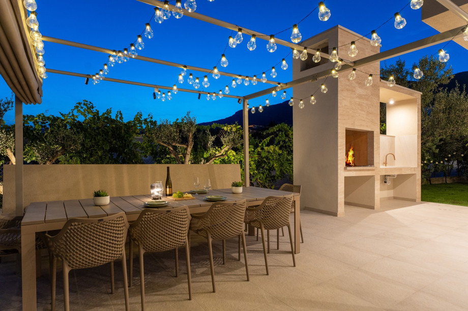 A shaded outdoor dining area with ambient lighting