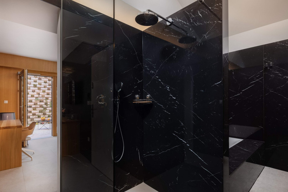 An en-suite bathroom with a bathtub and a shower, a double sink, a toilet, and a bidet.