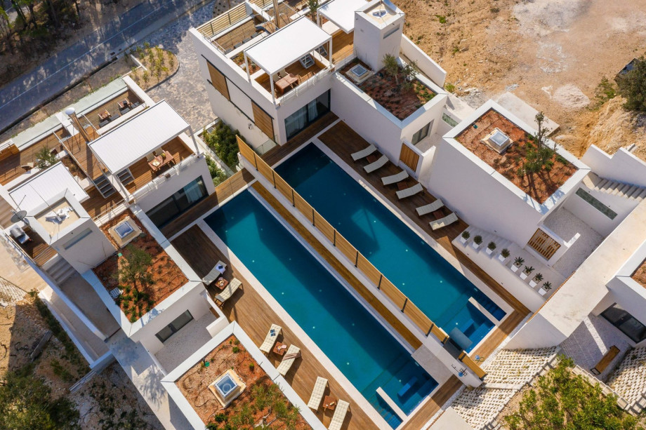 An outdoor lounge corner facing the refreshing pool, and an outdoor shower.