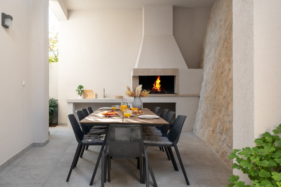 Behind the villa is a covered dining area with a traditional barbecue (wood/charcoal)