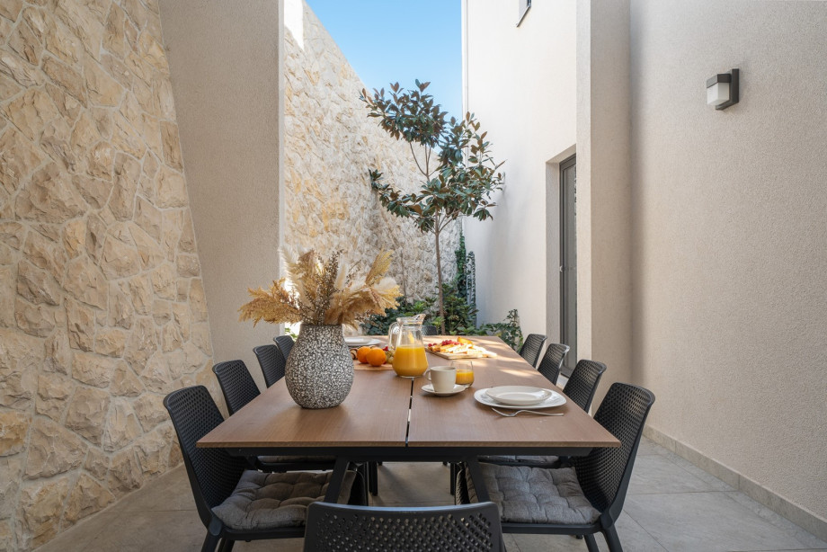 Covered dining area with a traditional barbecue (wood/charcoal) and a direct entrance to the kitchen