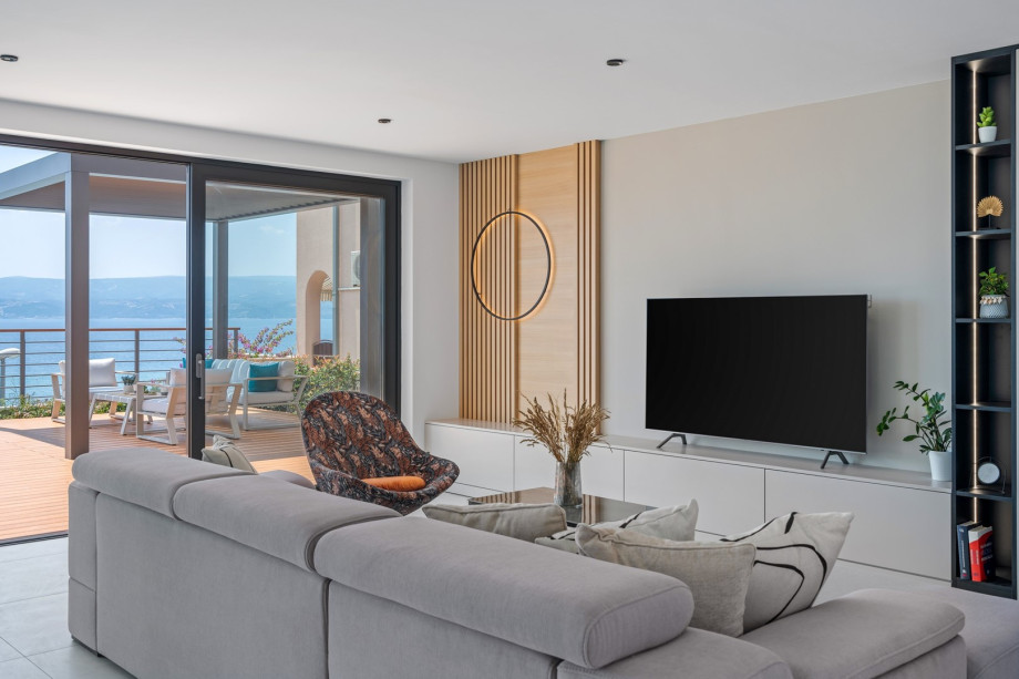 Modern furnished living area with exit to the pool.