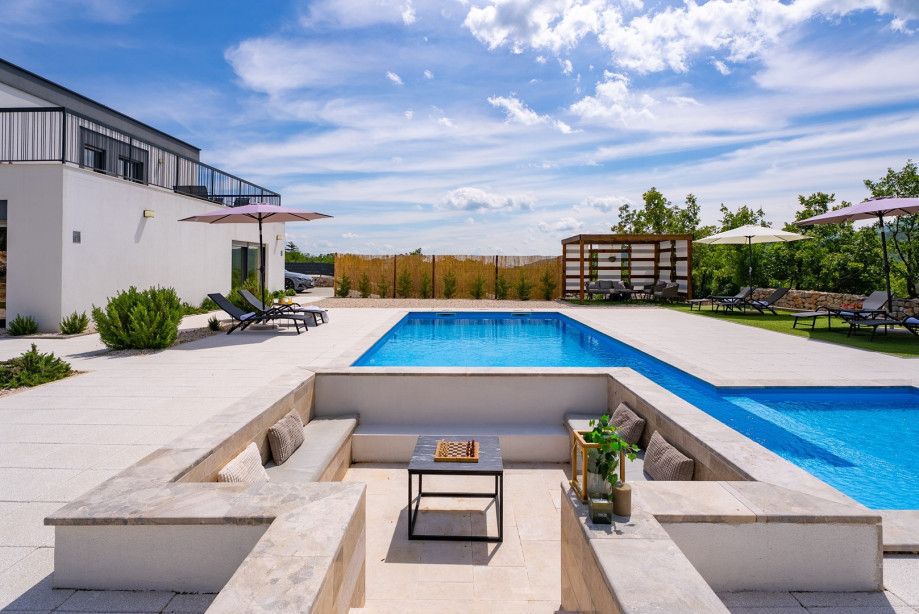 The outdoor offers a sun deck area with 8 deck chairs and artificial grass, a shaded lounge corner