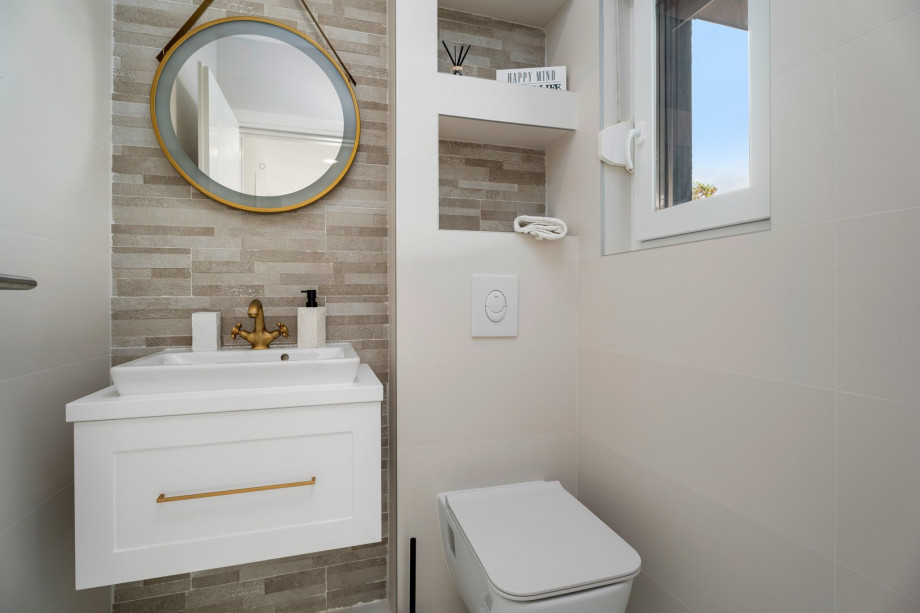 The ground floor offers a separate toilet and a laundry with washing machine and ironing amenities.