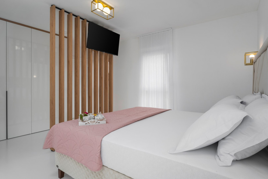 A TV, air-conditioner, en-suite bathroom with a shower, and a direct approach to the spacious terrace used by other bedrooms.