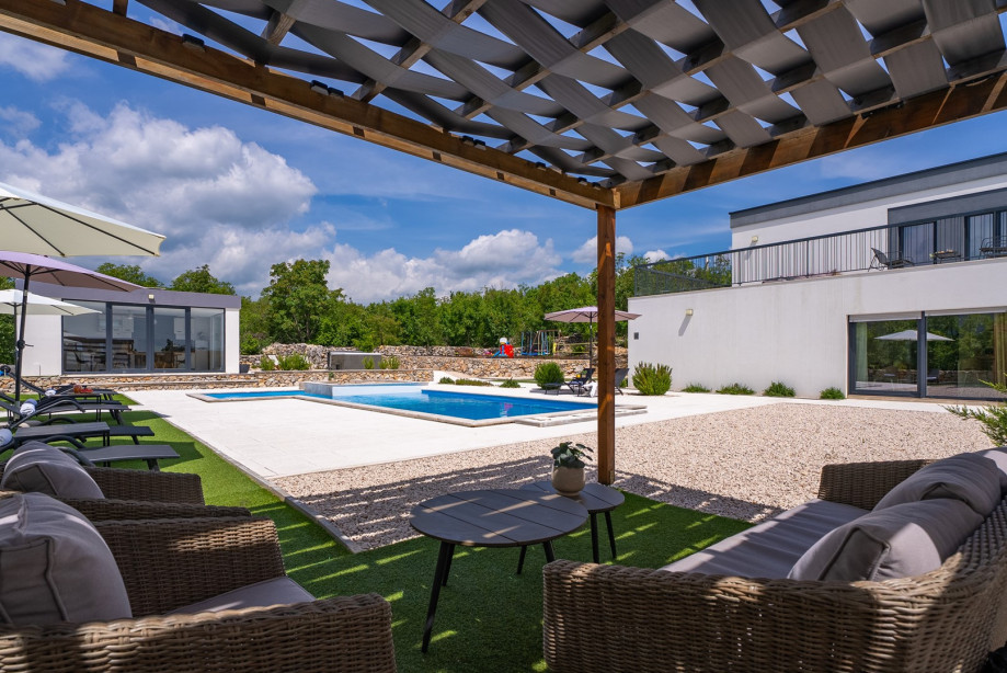 A fully equipped kitchen, a summer kitchen with a barbecue, and a dining table