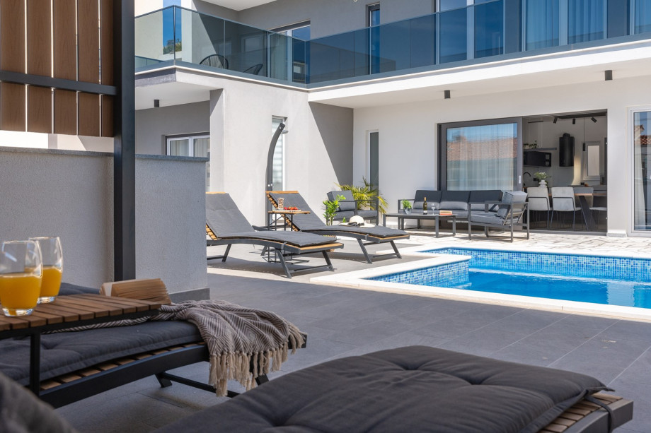 4 en-suite bedrooms, a summer kitchen, a sun deck area, and a PS4 and a tennis table.