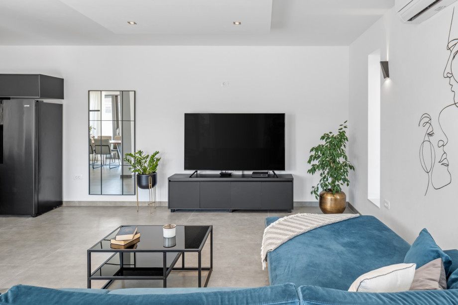 Spacious living room area with a flat-screen TV, PS4, free WiFi, with a direct approach to the pool area