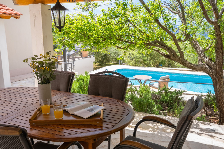 There is a covered outdoor dining area and a traditional barbecue