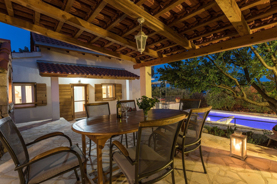 Outdoor dining table with nice lights next to BBQ
