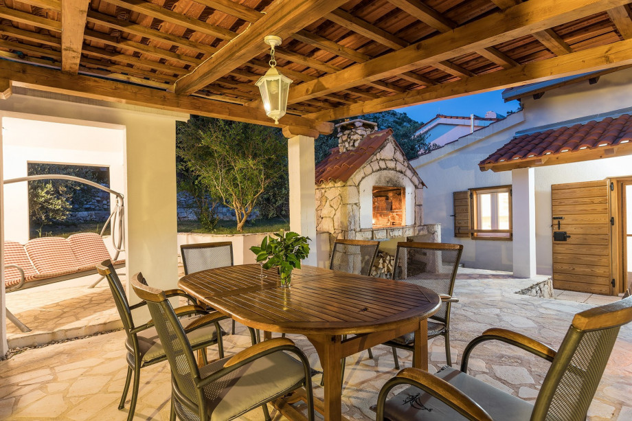 Outdoor dining table with nice lights next to BBQ