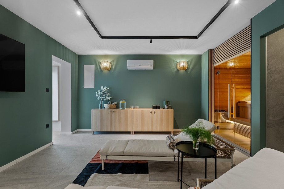 Treat yourself to spa-like bliss in the inviting spa room, featuring a Finnish sauna, kitchenette, shower, and relaxing deck chairs.