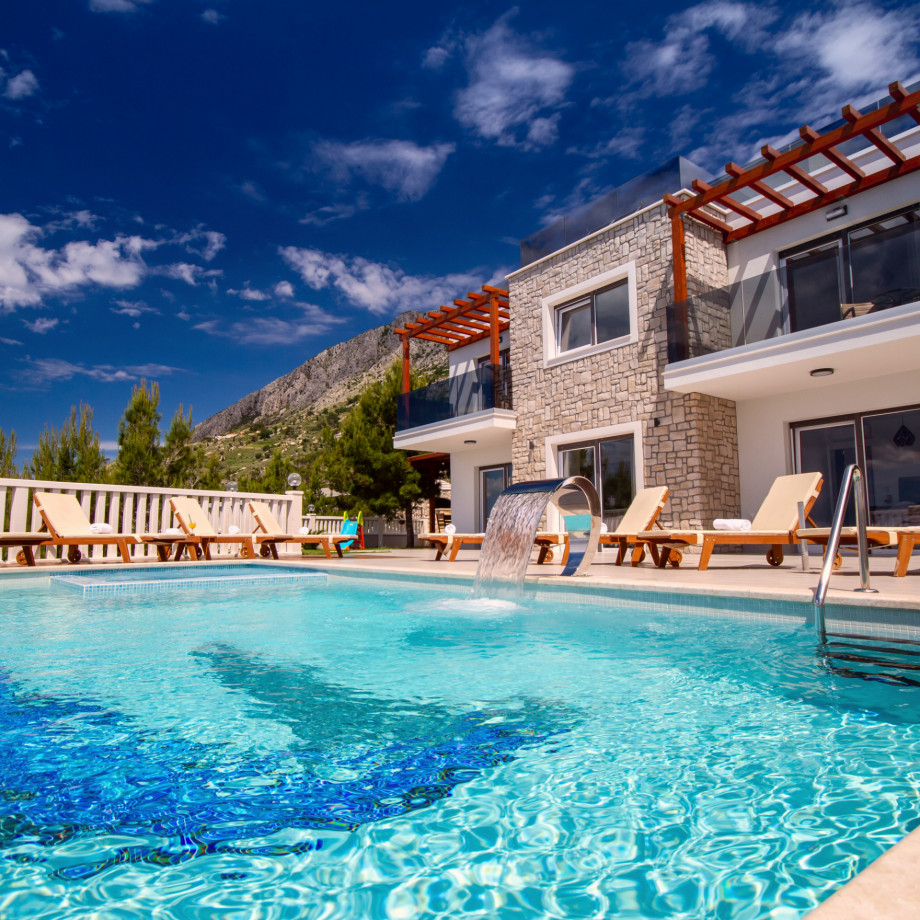 Modern and luxury property with heated pool, decked area, and 8 lounge chairs