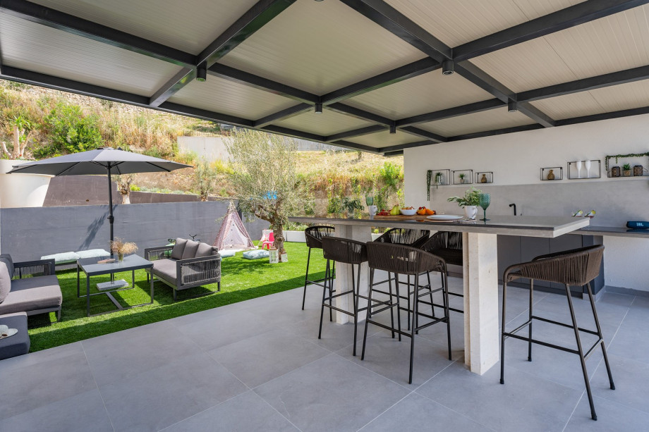 Outdoor area equipped with a traditional wood and charcoal grill ideal for special culinary experiences