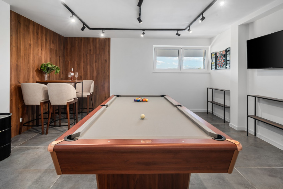 There is a fun zone with a Billiard (Pool table), darts, a TV and bar table, a bathroom with a shower