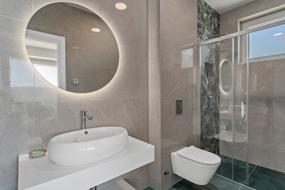 An en-suite bathroom with a shower, a sink, and a toilet