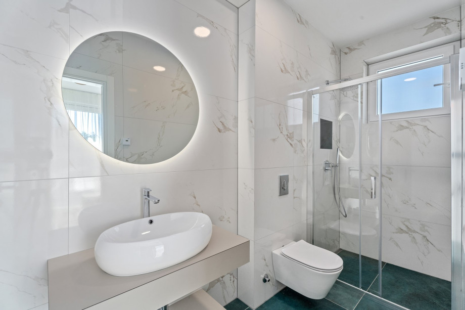 An en-suite bathroom with a shower, a sink, and a toilet