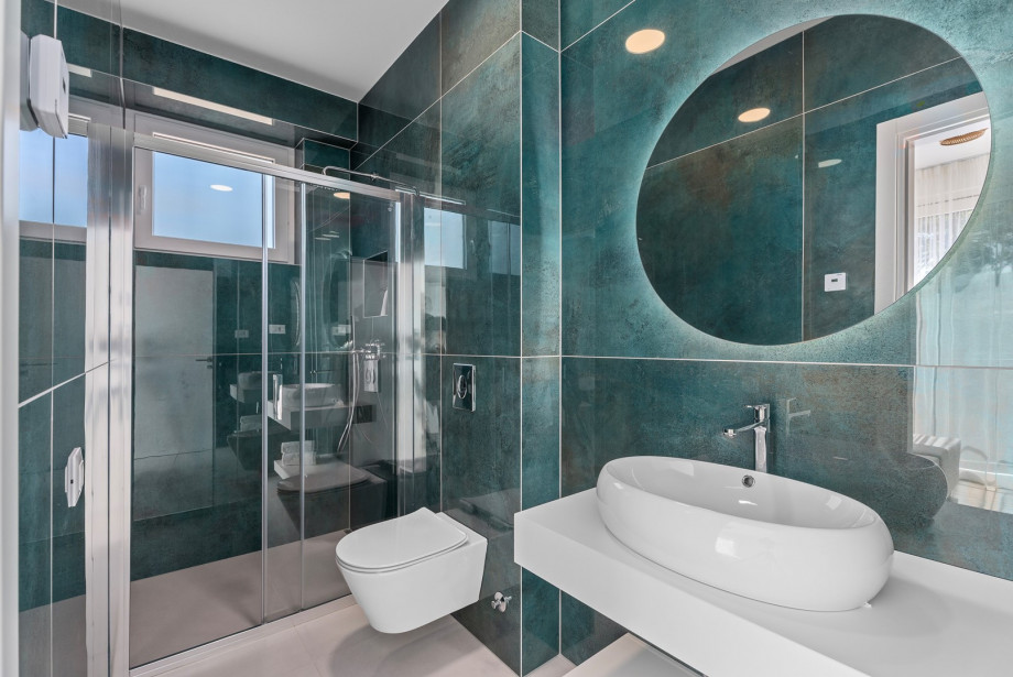 An en-suite bathroom with a shower, a sink, and a toilet