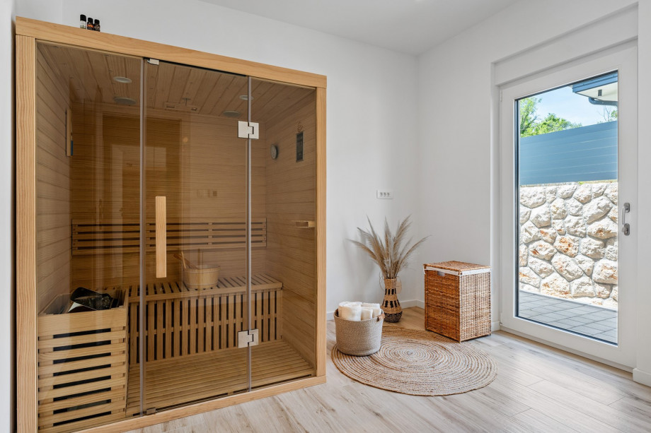 A relaxing Sauna room with a door toward the outdoors and the pool area