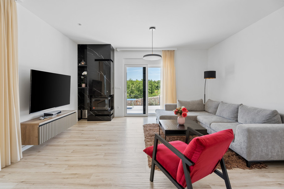 Das elegant eingerichtete Wohnzimmer verfügt über bequeme Sofas, einen Fernseher und eine Klimaanlage