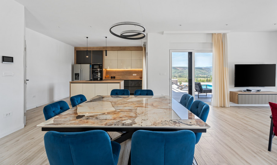 As you step inside, you are greeted by a seamless open-plan living, dining, and fully equipped kitchen area with a kitchen island